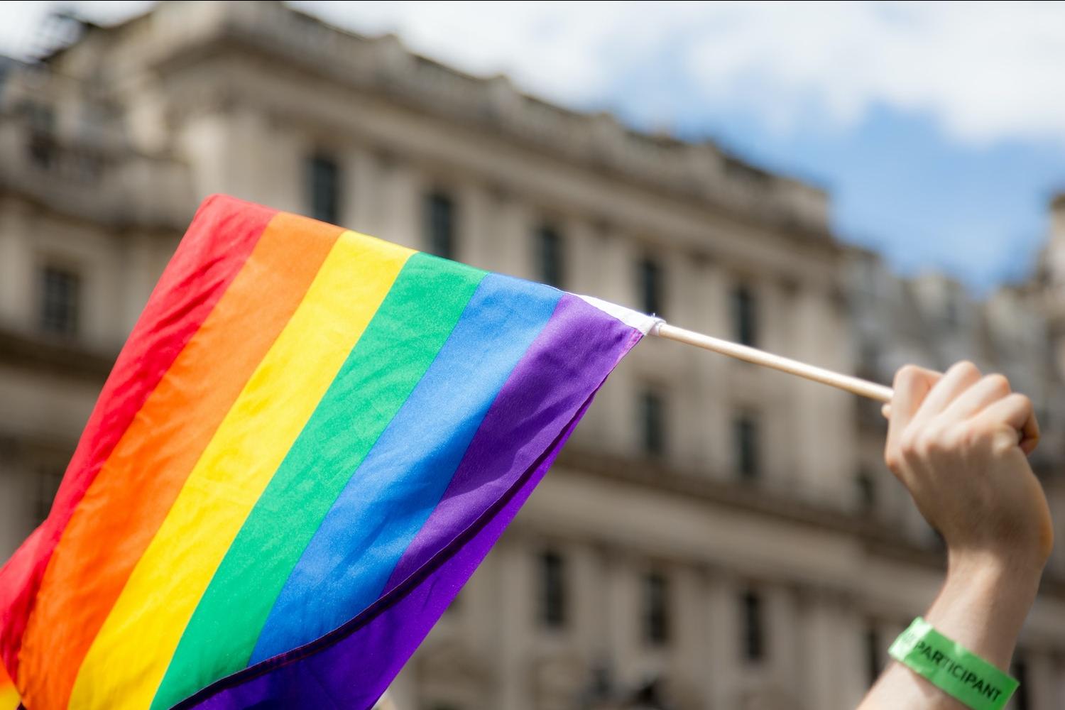 hand holding lgbtq pride flag - supporting pride amidst boycotts